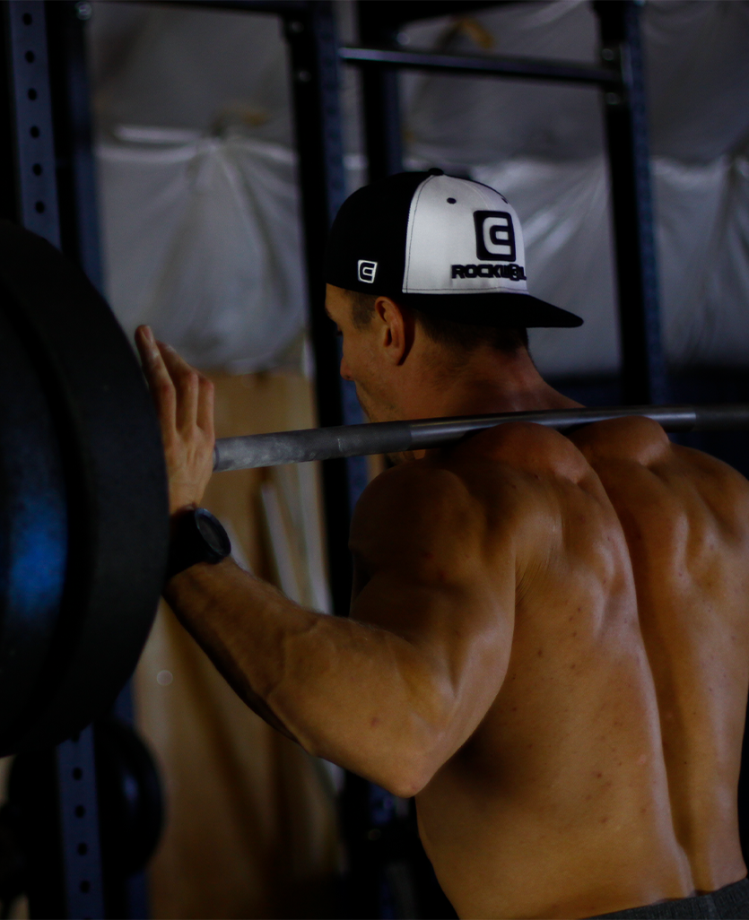 man lifting weights while wearing the o g rockwell black/white snapback hat