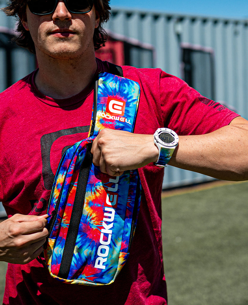 man wearing rockwell shoulder sling tie dye bag. showing the coliseum with tie dye bands 